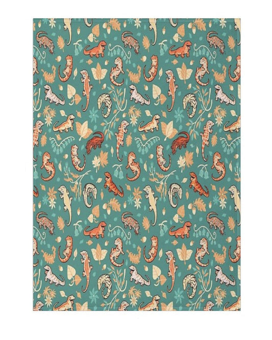 blanket with patterned design of geckos and autumn leaves