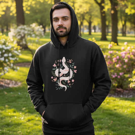 man wearing a botanical serpent hoodie in a park