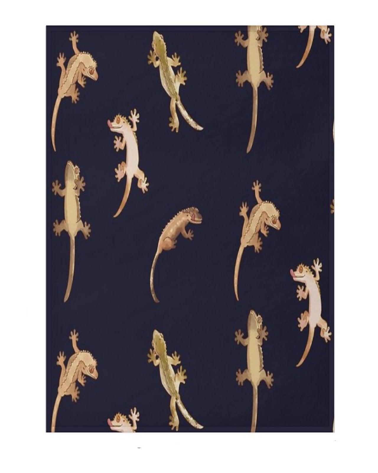A blanket shown flat against a white background, featuring a repeating gecko pattern on a black base. 