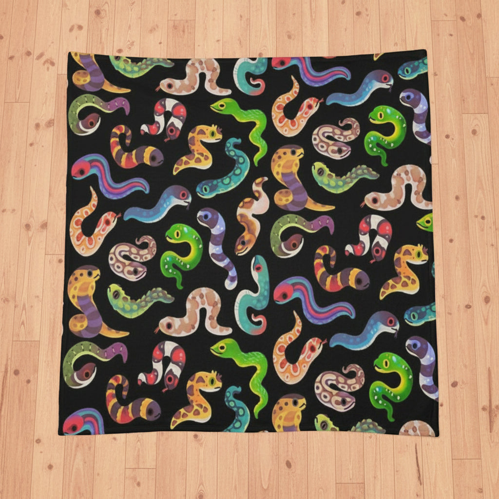 a black blanket or throw featuring a colorful repeating pattern of cartoonish colorful snakes
