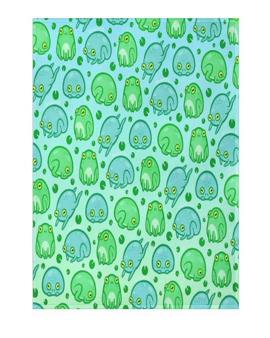 A blanket with a pattern of green and blue frogs on a blue background