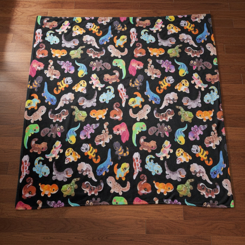 blanket with a colorful gecko pattern on a black background