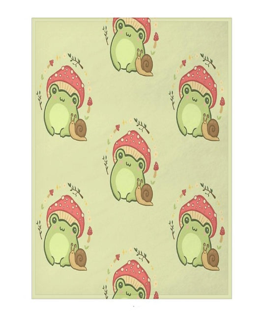 a blanket with a repeating cartoon frog pattern wearing a red mushroom hat and holding a snail, on a pale yellow-green base.