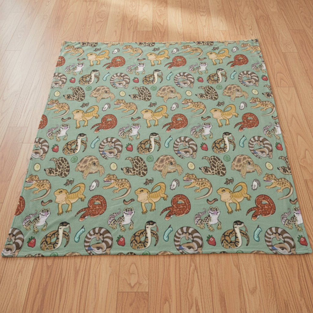 a blanket featuring a collage of reptiles on a light blue background