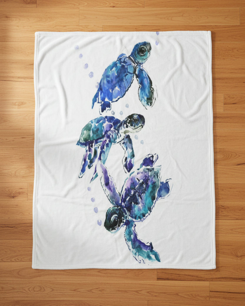 throw blanket featuring a watercolor design of three sea turtles